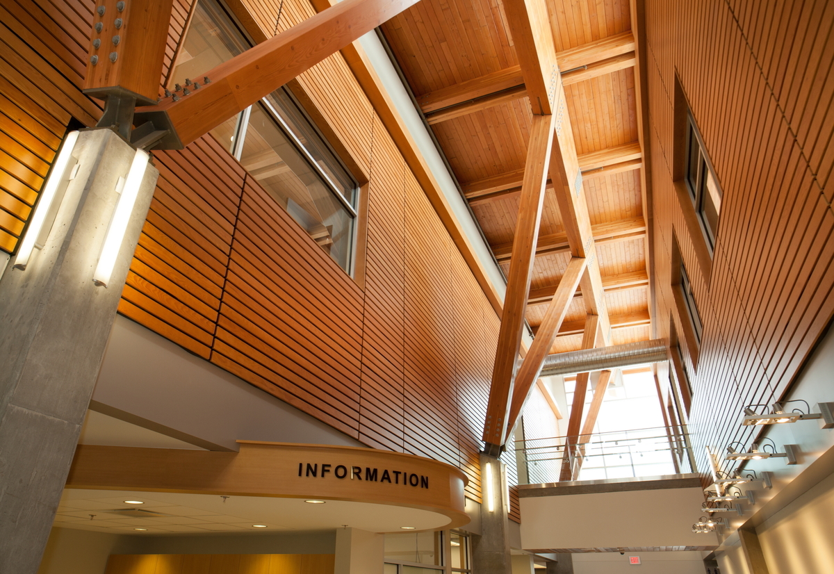 北部BC癌症机构中心低层的室内日间景观，显示胶合层压木材、实锯重木材、木镶板和装饰物