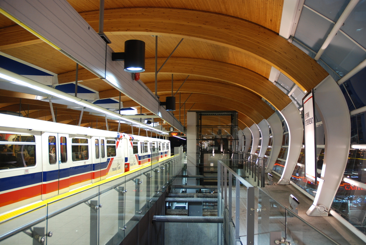 大型拱形钉层压木材(NLT)梁支撑着木质天花板，这是本纳比市布伦特伍德镇中心公交车站内部景观的突出特征