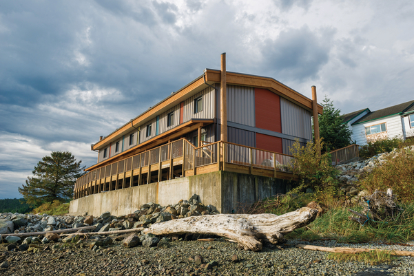下午的室外海岸线景观，俯瞰模块化被动式房屋/高性能贝拉贝拉员工住房，由12个预制模块建造，包括实心锯厚木材和定向刨花板(OSB)