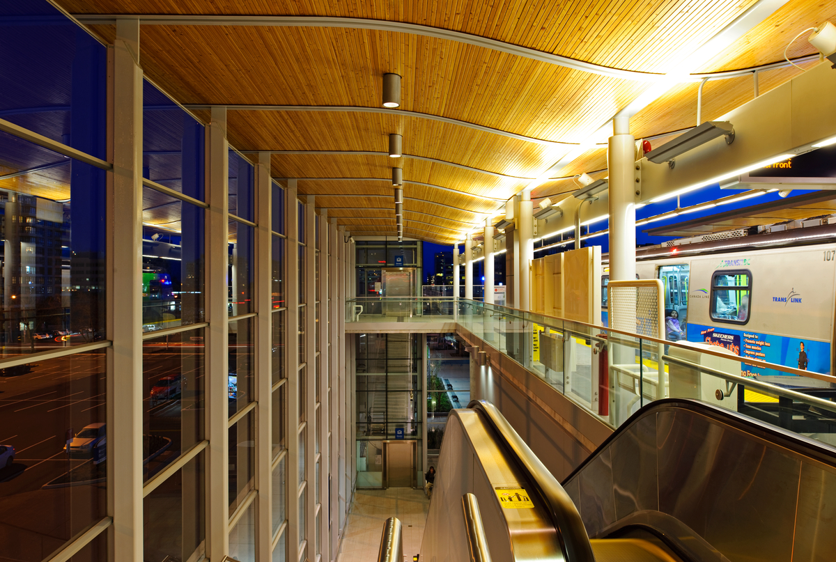 傍晚的Lansdowne加拿大线车站有木制细节天花板，壶灯和车站的轻轨。自动扶梯在前景。