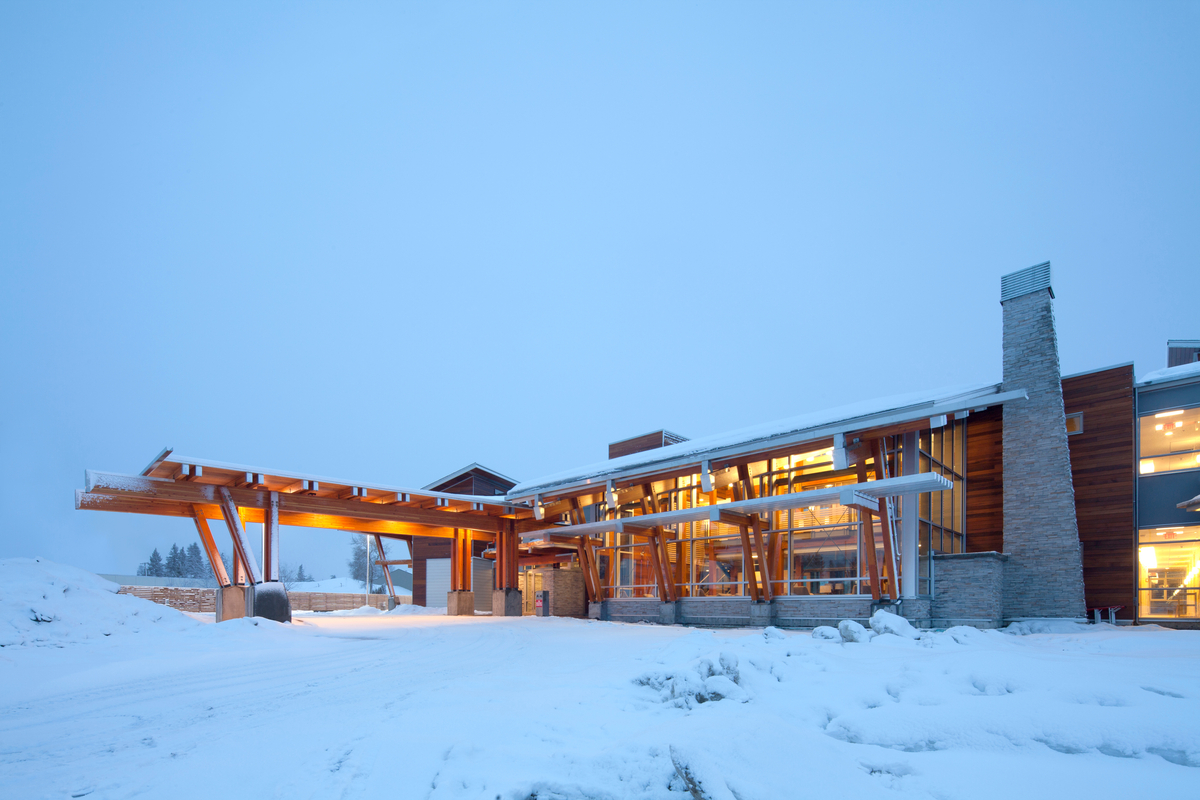 加拿大癌症协会科尔迪班小屋的低层两层，冬季白天下雪的外观，显示胶合层压木材(胶合木)和装饰壁板