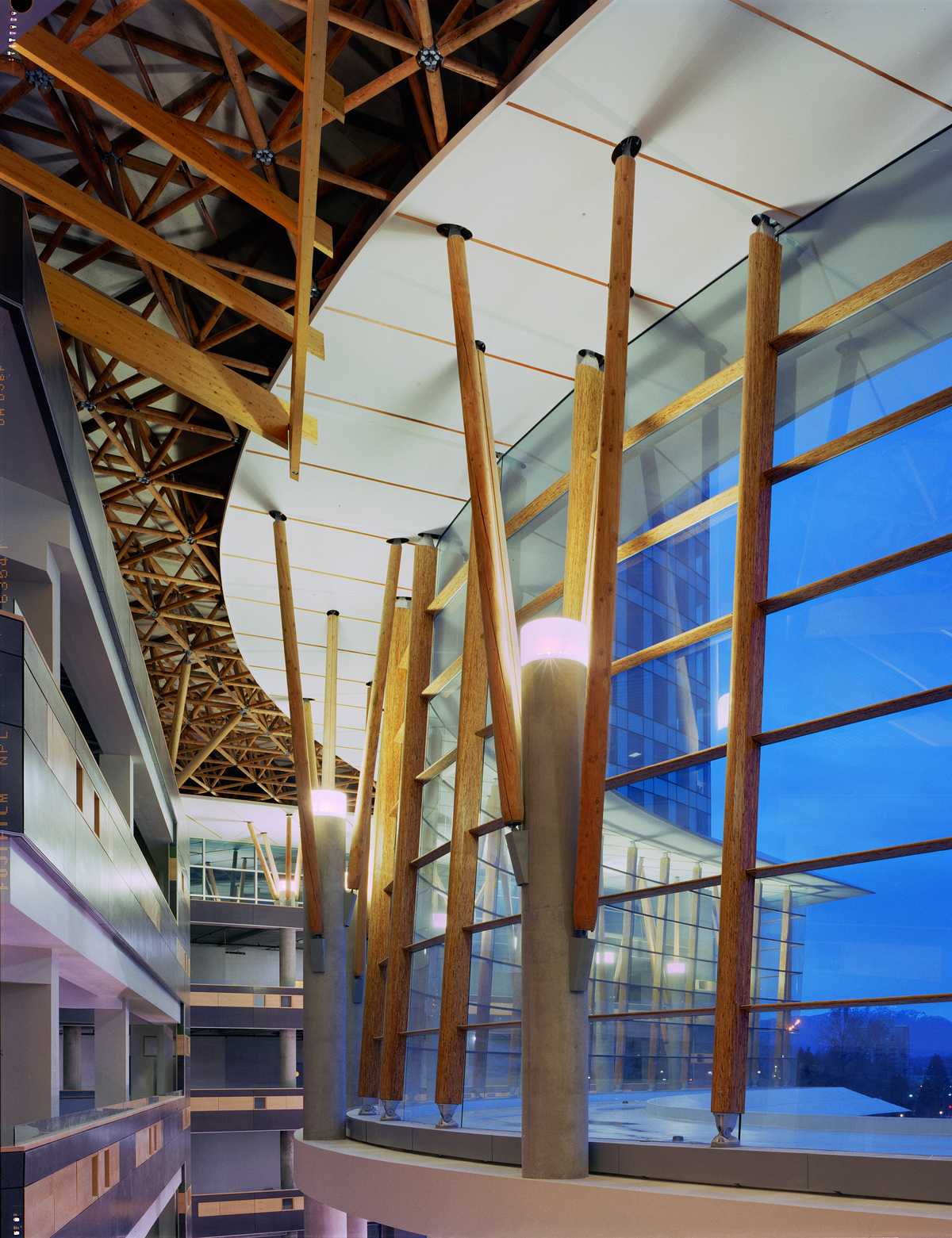 萨里中心城市正面的室内夜景展示了由混凝土和胶合木(胶合木)、平行股木(PSL)和实锯重木材支撑的多层玻璃