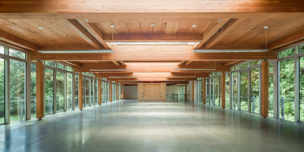 新落成的Cheakamus Centre蓝海岸环境学习中心日间室内景观，展示交叉层压木(CLT)胶合木(胶合木)梁，支撑木板屋顶系统