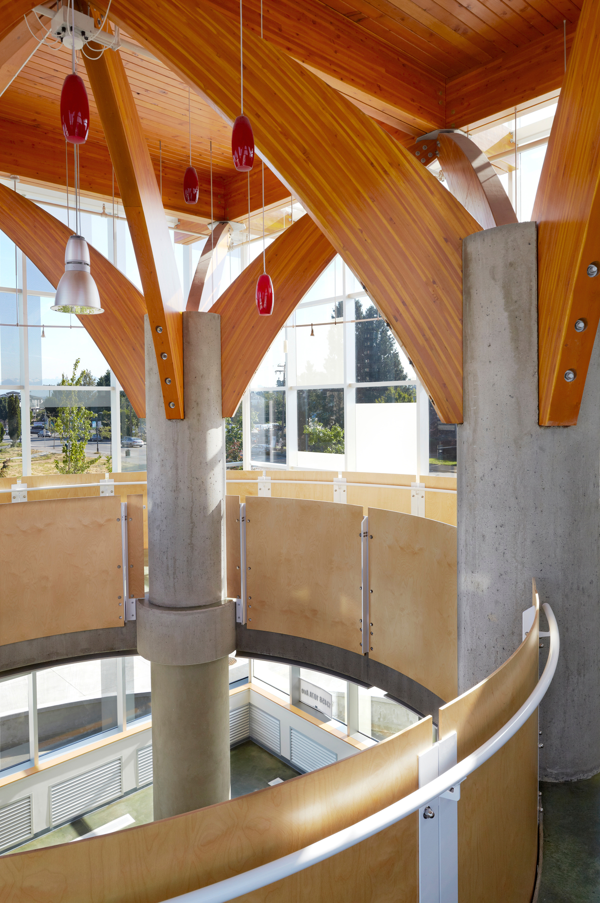 查克贝利娱乐中心低层建筑的室内阳光午后景观，以混凝土柱上的胶合木(胶合木)屋顶支撑为特色