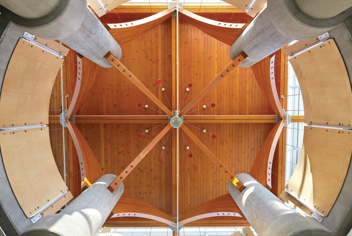 室内阳光明媚的下午向上的低层查克贝利娱乐中心的垂直视图，以巨大的结构胶合木(胶合木)屋顶支撑在混凝土柱上