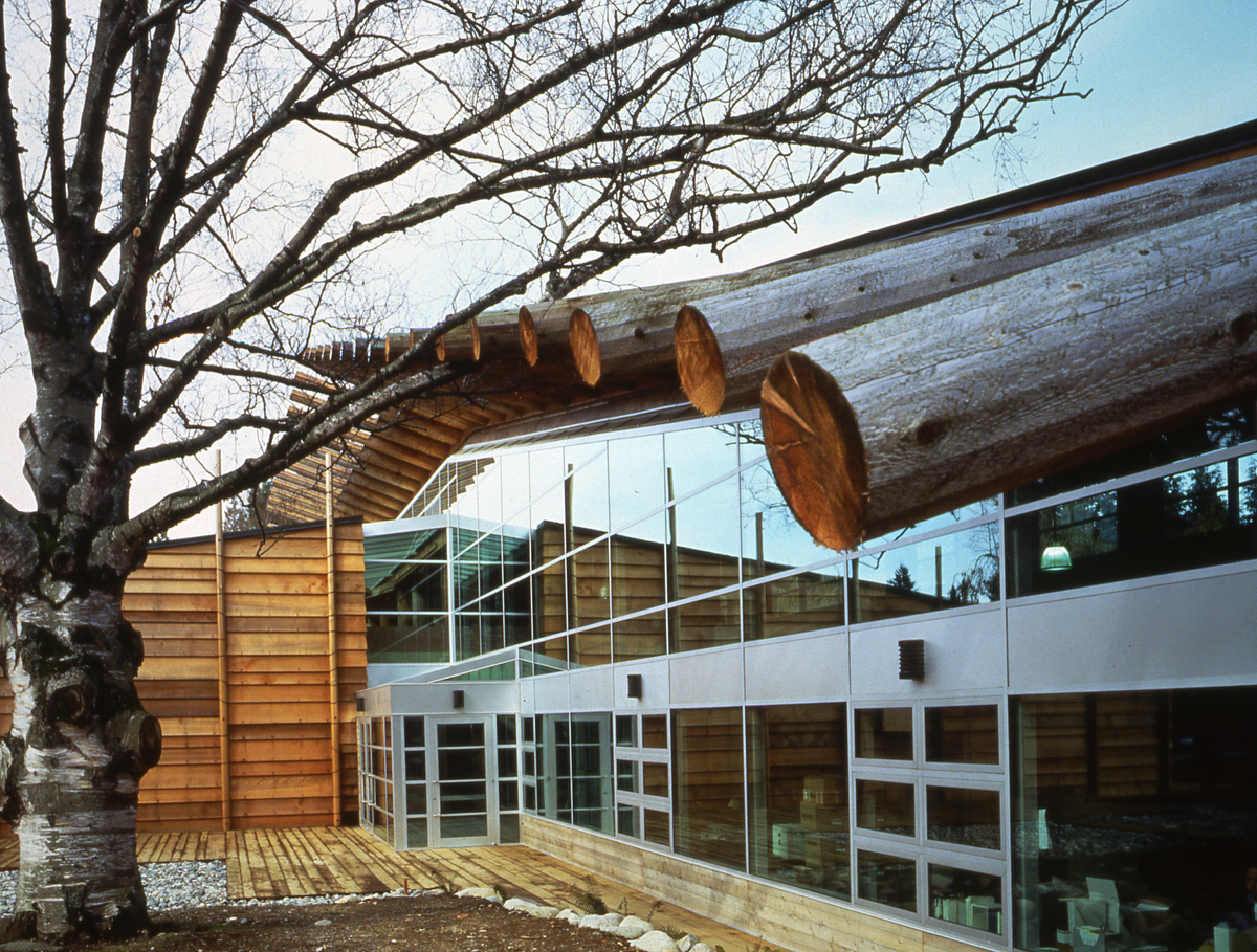 在这张多云的下午的UBC校园第一民族长屋的照片中，粗糙的船板和实心锯厚的雪松木材是主要的特征