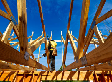图为建筑工人用钉枪和防坠装置在低层住宅结构上安装的轻型结构梁和屋顶桁架