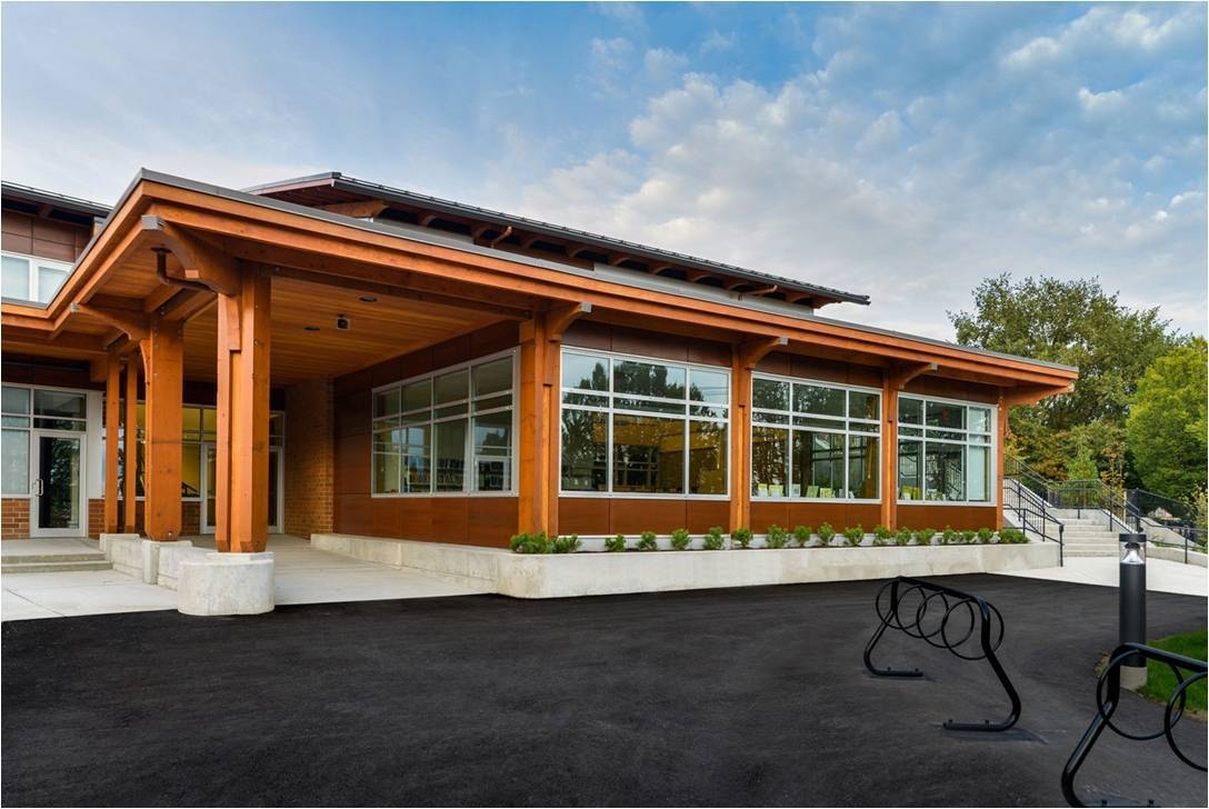J.W. Sexmith小学阳光明媚的白天景观，展示由胶合木(胶合木)梁、平行绞线木材(PSL)和实锯重木材建造的大木材覆盖的走道