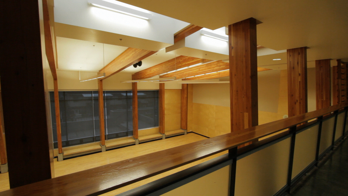 大卫王高中二楼的阳台走道，俯瞰着多用途的避难所，木地板和暴露的胶合木(胶合木)横梁和柱子
