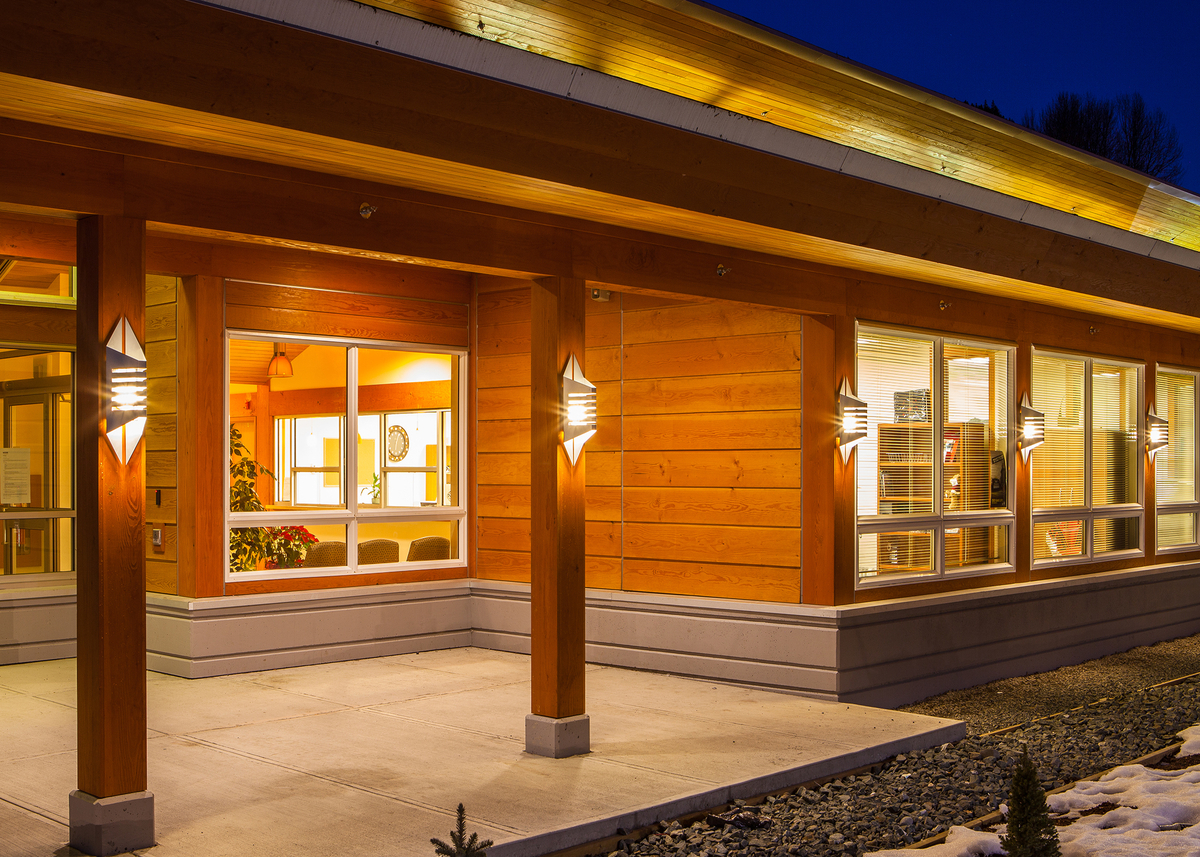 低层建筑Kitsumkalum健康中心的外部夜景，展示了木材组件的广泛使用，包括镶板、胶合板、墙板和道格拉斯冷杉和西部红雪松的实锯重型木材