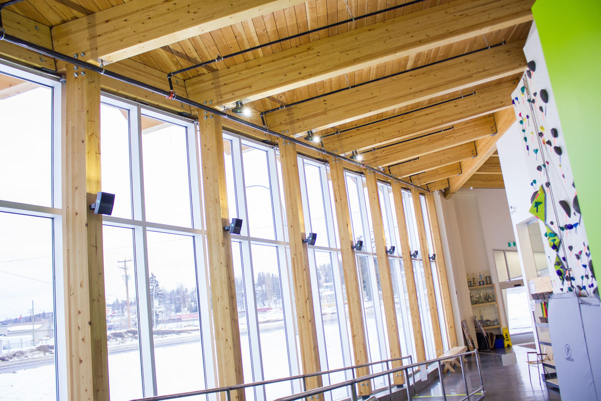 伯恩斯湖湖滨综合公寓的阳光室内冬季图像，显示实心木板甲板和胶合木梁和支撑柱裸露的屋顶结构