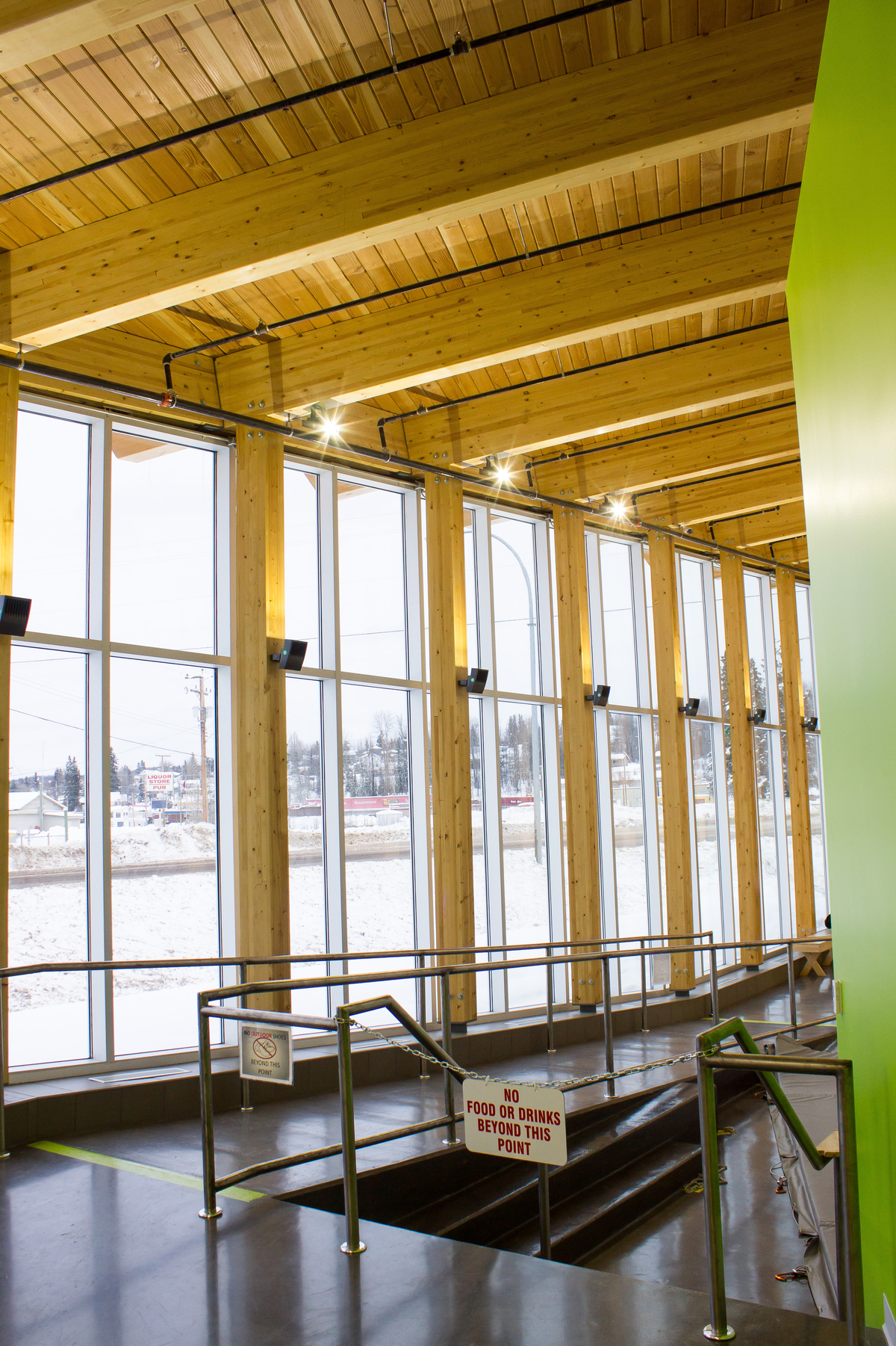 伯恩斯湖湖滨综合公寓的阳光室内冬季图像，显示实心木板甲板和胶合木梁和支撑柱裸露的屋顶结构