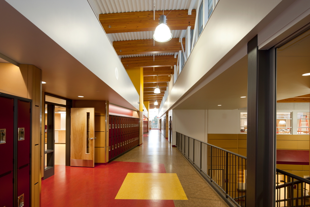 北萨尼奇中学多层主厅的内部视图，展示了混合金属、木材和混凝土结构，包括实心块木镶板、柱+梁和胶合木(胶合木)梁