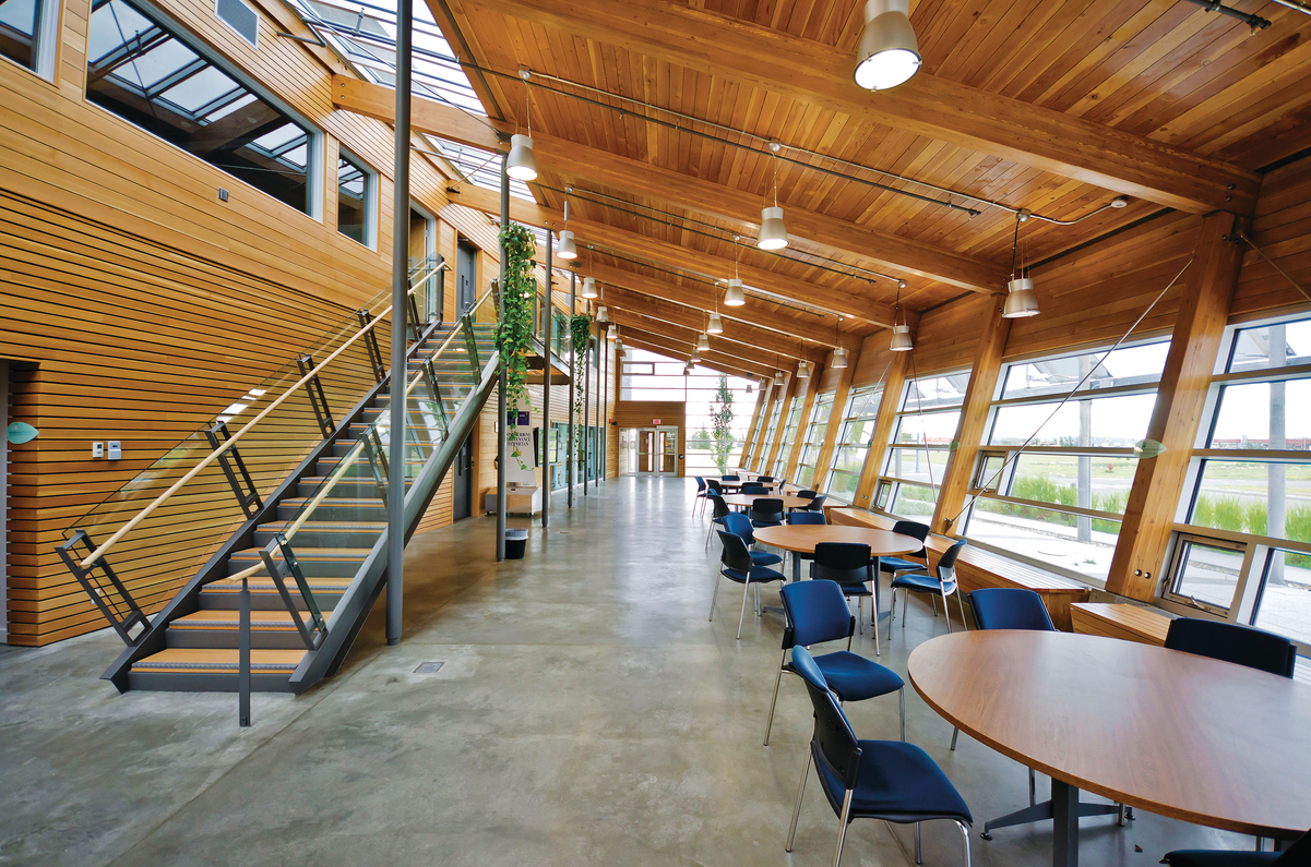 北极光学院能源屋的日间室内景观，展示了道格拉斯冷杉和西部红雪松木用于舌槽天花板木制品、木饰墙和胶合木(胶合木)橱柜和柜台