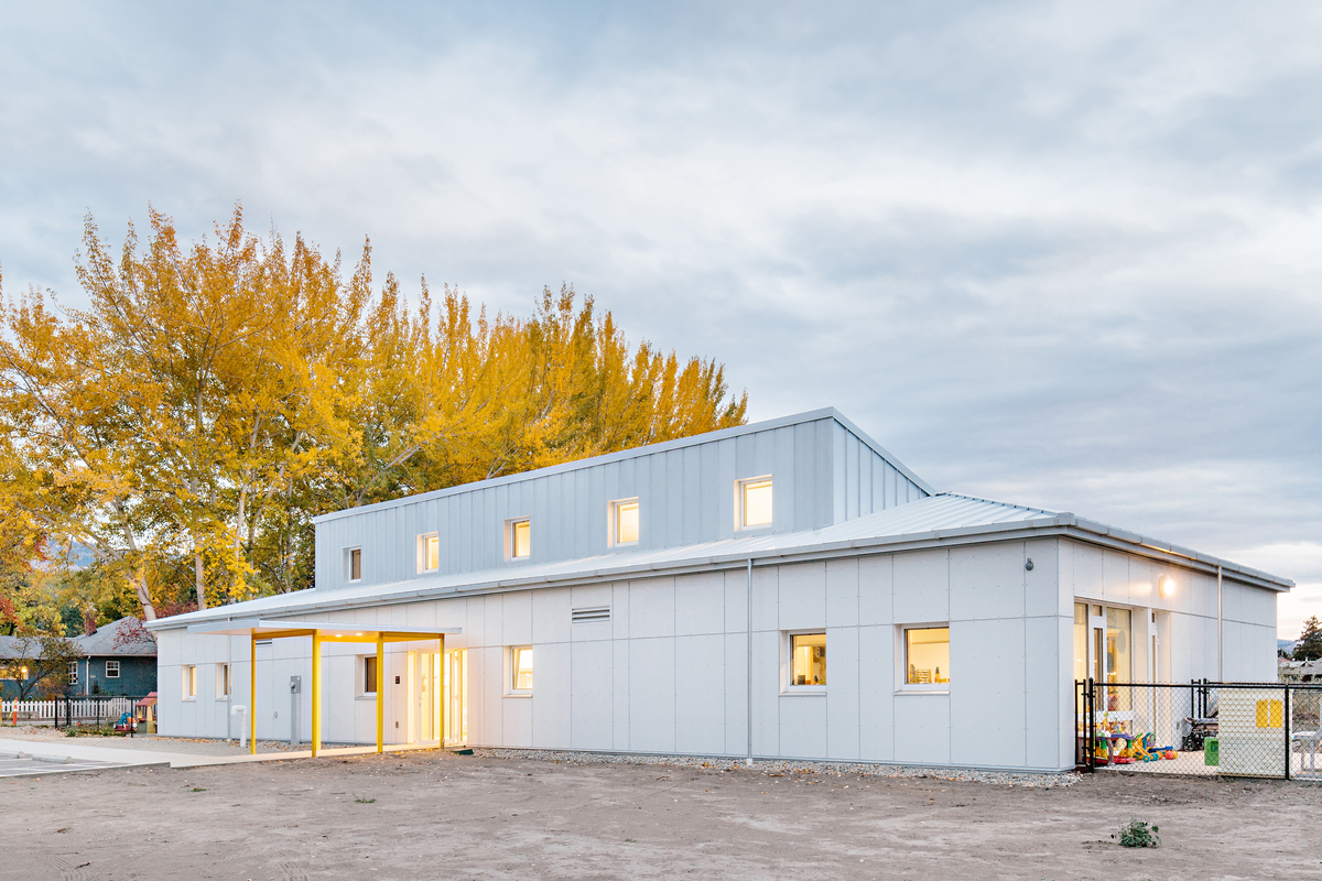 奥卡那根学院幼儿中心低层建筑的阴天景观，展示了轻框架和大量木结构的混合结构，包括交叉层压木材(CLT)、层压单板木材(LVL)和预制构件