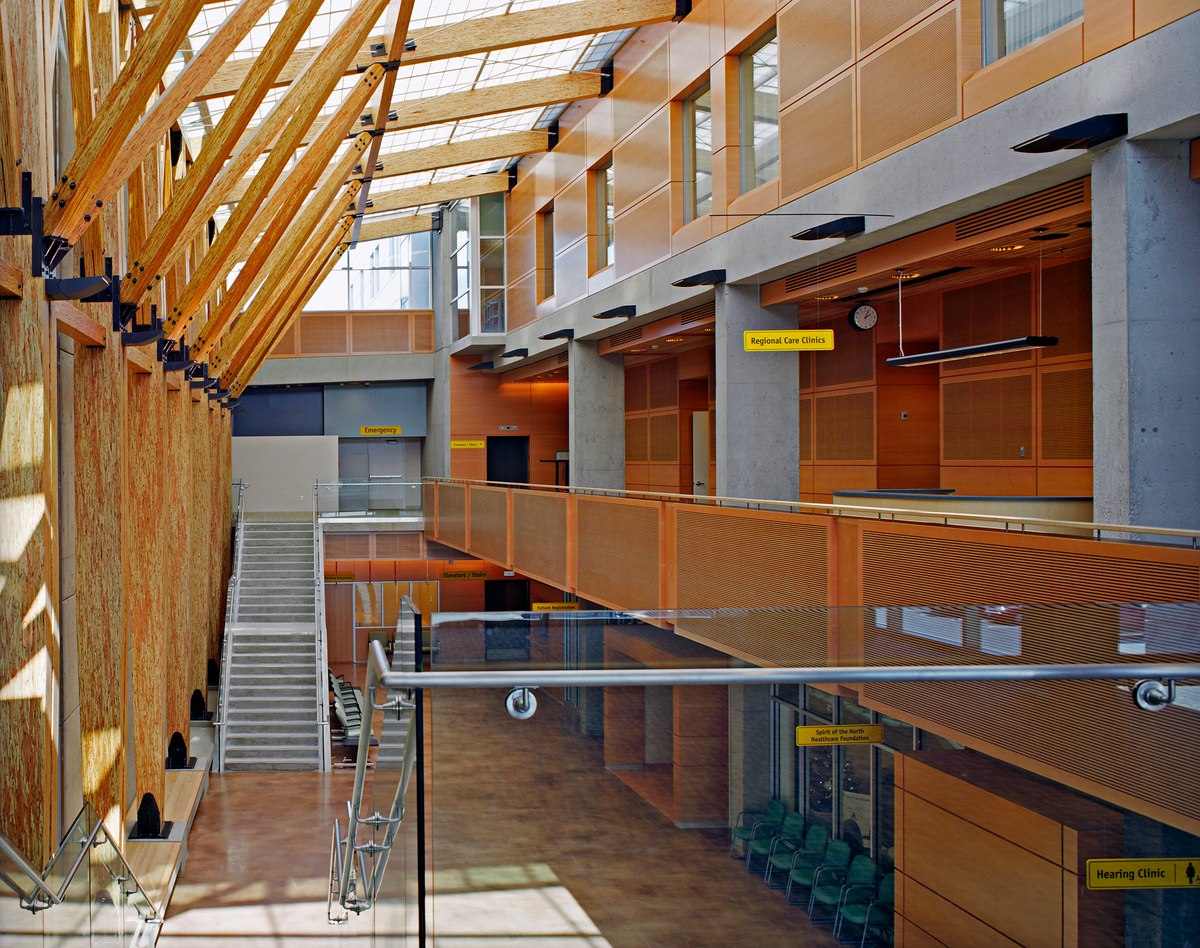 卑诗省北部三层大学医院的室内中庭视图，除了装饰木墙板和镶板外，还采用了结构胶合层压木材(胶合木)和平行股材(PSL)