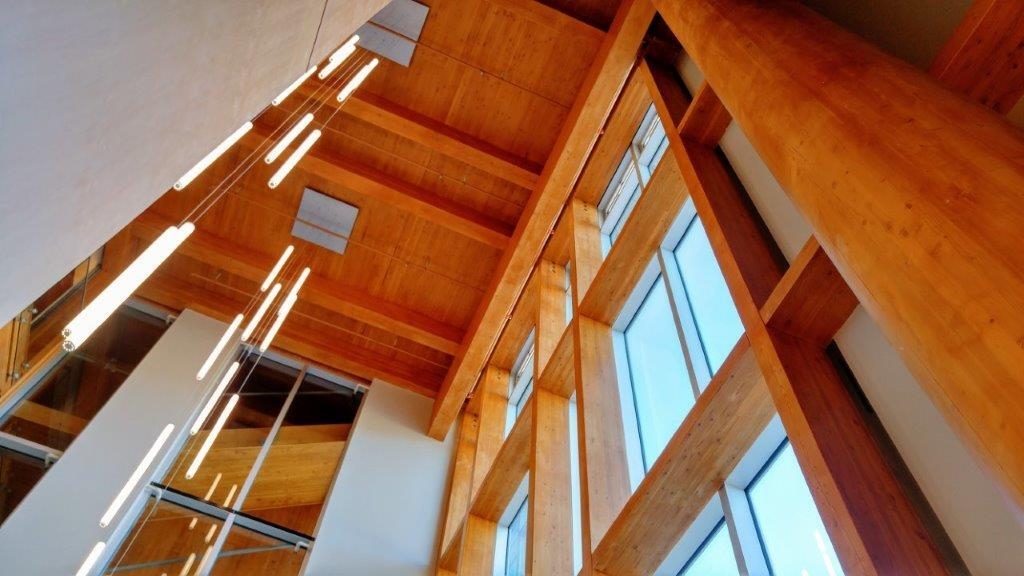 彭提顿湖畔度假酒店和会议中心西翼内的多层中庭天花板向上视图展示了艺术吊灯，突出了暴露胶合层压木材(胶合木)和交叉层压木材(CLT)的广泛使用。