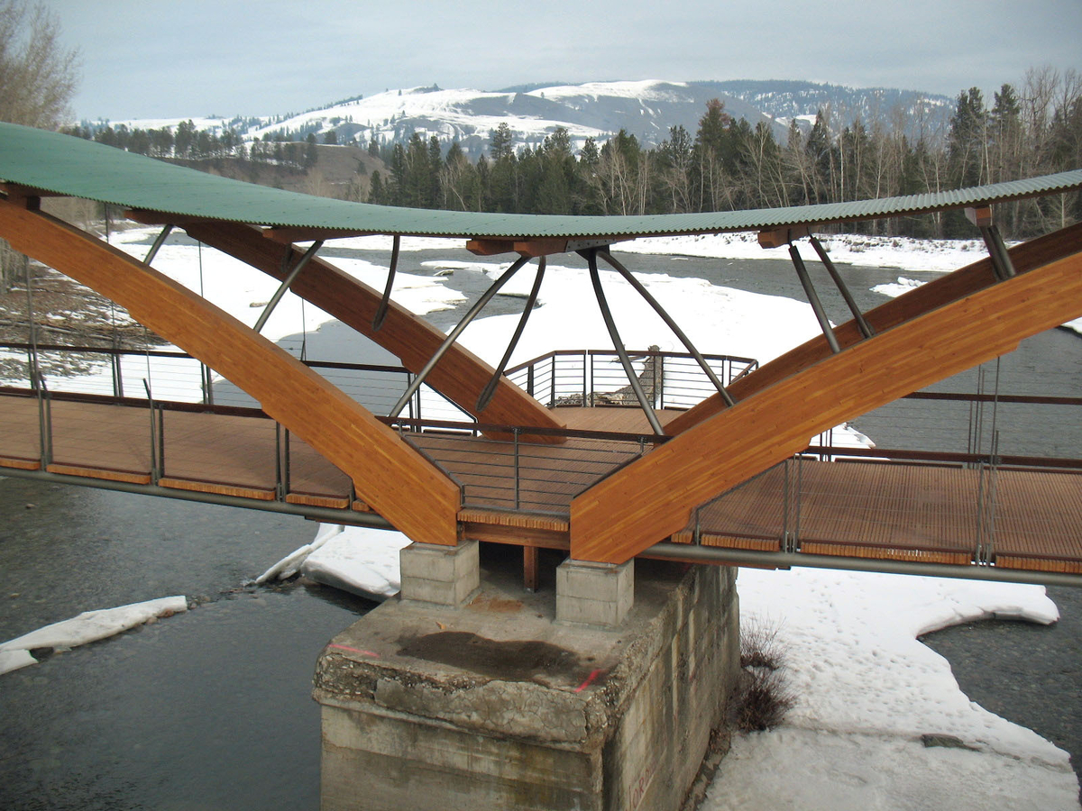普林斯顿梦之桥的户外阴雪图像显示了大型胶合木(胶合木)拱门和木甲板