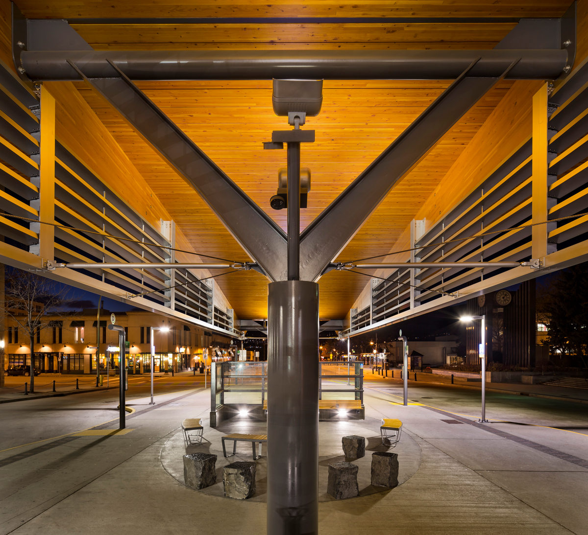 夜间户外近景钢柱支撑60米长的曲线屋顶跨度，通过使用两根工程胶合木梁支撑9米宽的甲板板实现