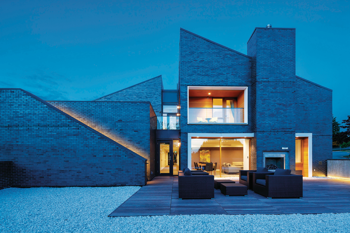 育空省罗纳德麦克唐纳住宅的室外夜景屋顶，展示了交叉层压木材(CLT)、砖石和轻框架结构的创新组合