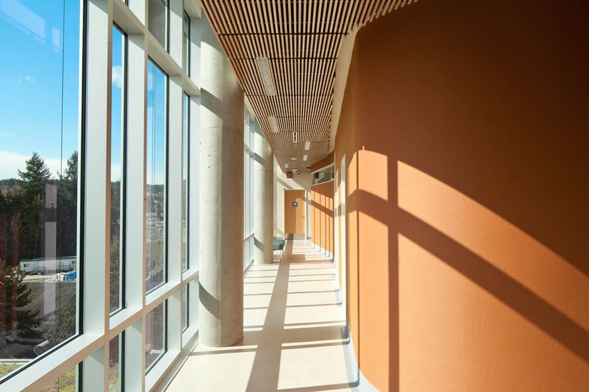 Sechelt医院内部，阳光洒在陶土墙上，天花板上有木制木制品