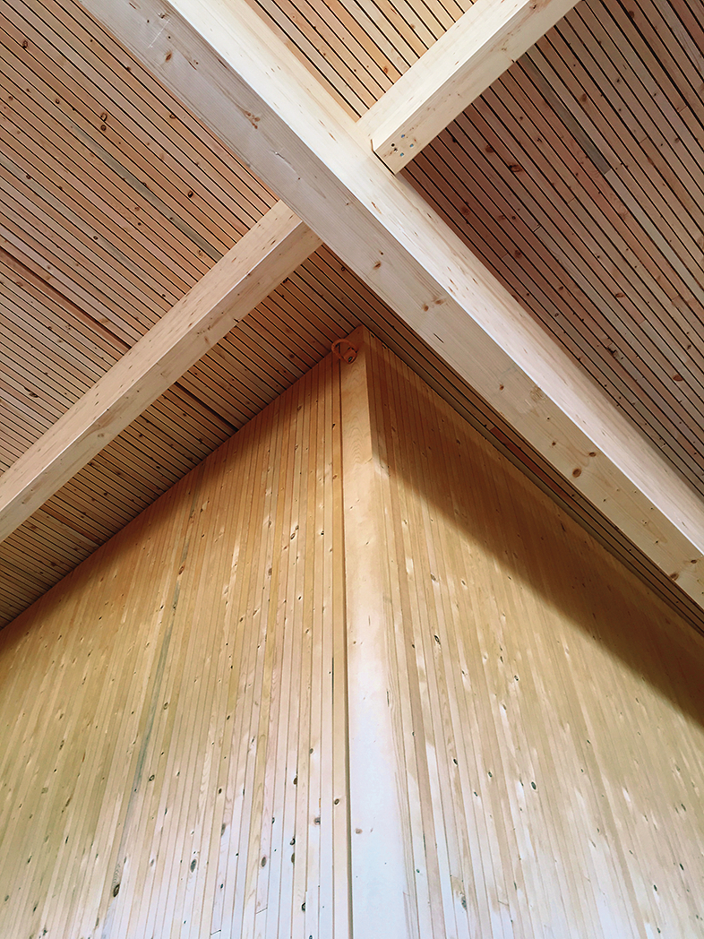 内部近距离观察胶合层压木材(胶合木)柱和梁，高木墙，木屋顶板，如图所示在StructureCraft制造设施
