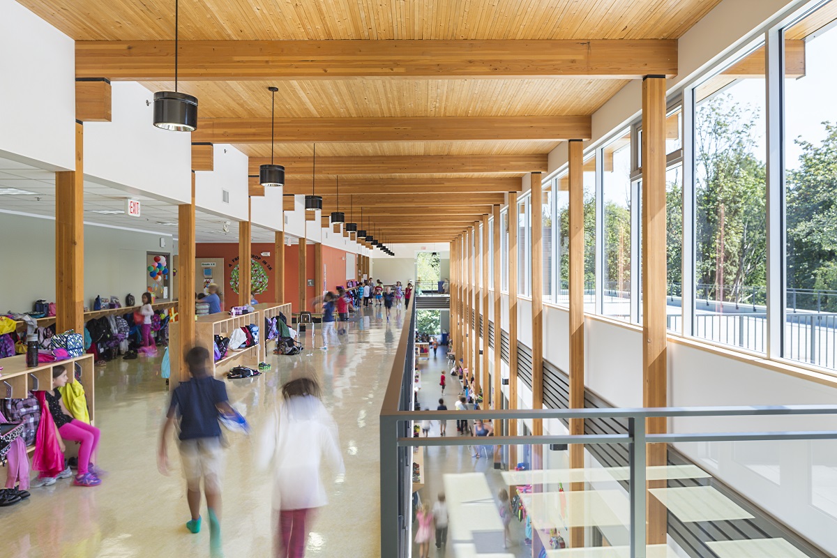 阳光明媚的白天，萨里基督教学校小学翼内的二层儿童视图，展示了大量的木结构，包括胶合层压木材(胶合木)和交叉层压木材(CLT)
