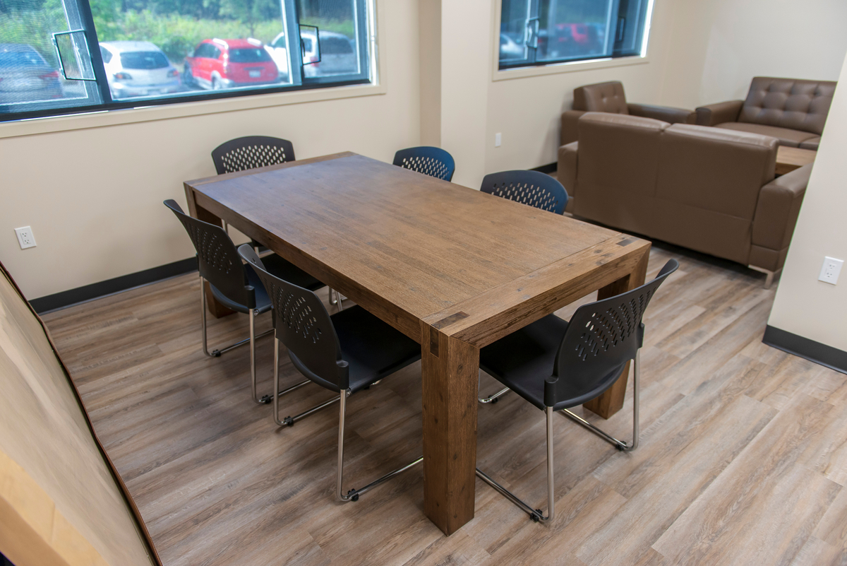 西三一大学雅各布森大厅学习区域的内部视图显示木地板，沉重的木桌，棕色躺椅，阳光通过窗户进入