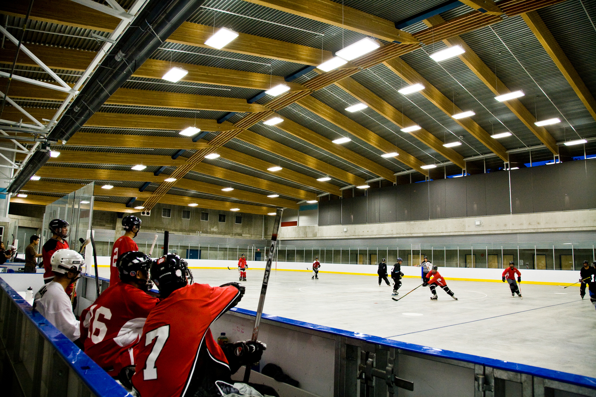 特劳特湖冰场的内部占位视图显示胶合木(胶合木)屋顶设计在冰场上面与冰球运动员下面