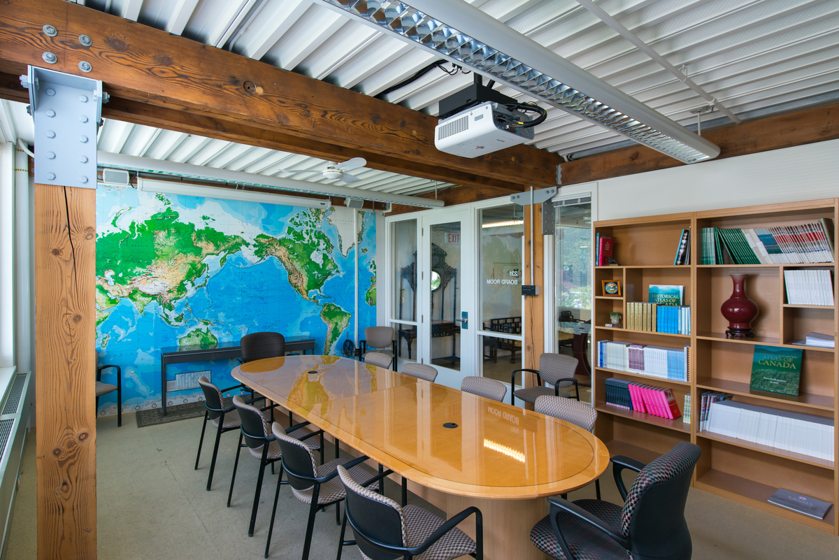 UBC CK Choi建筑板房的日间室内图像，显示实木锯重木梁和柱，与相关的金属配合板，木桌和书架