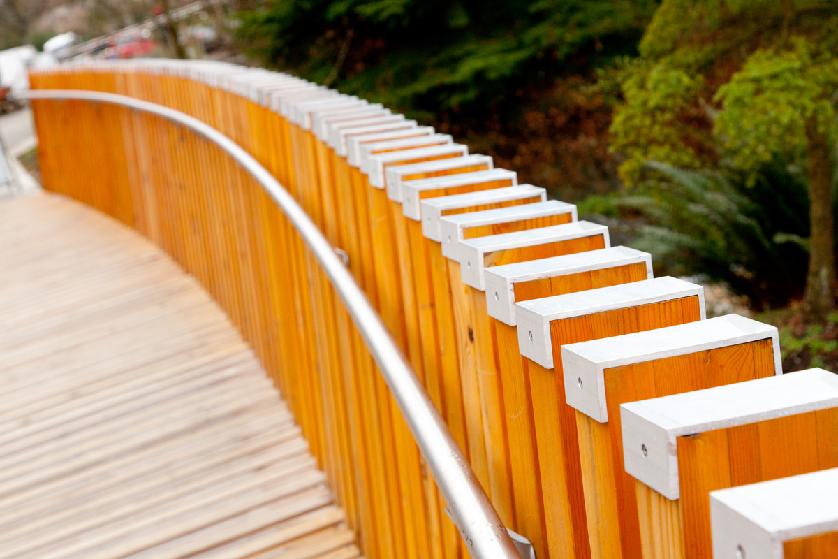 凡德森植物园游客中心的室外阳光特写图片，展示了由尺寸木材和金属制成的垂直扶手支撑，结合了装饰性