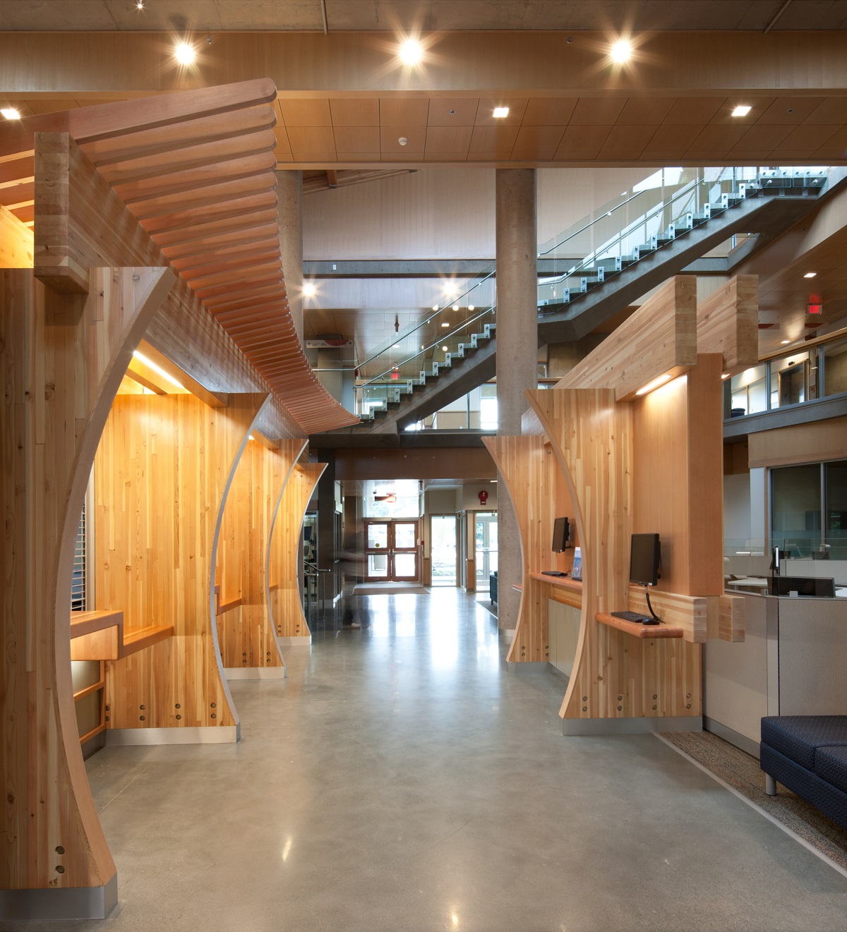 胶合木(胶合木)梁和装饰工作台隔板、木材装饰和装饰木材元素都展示在温哥华岛大学考伊坎校区的多层主入口和中庭的白天室内图像中