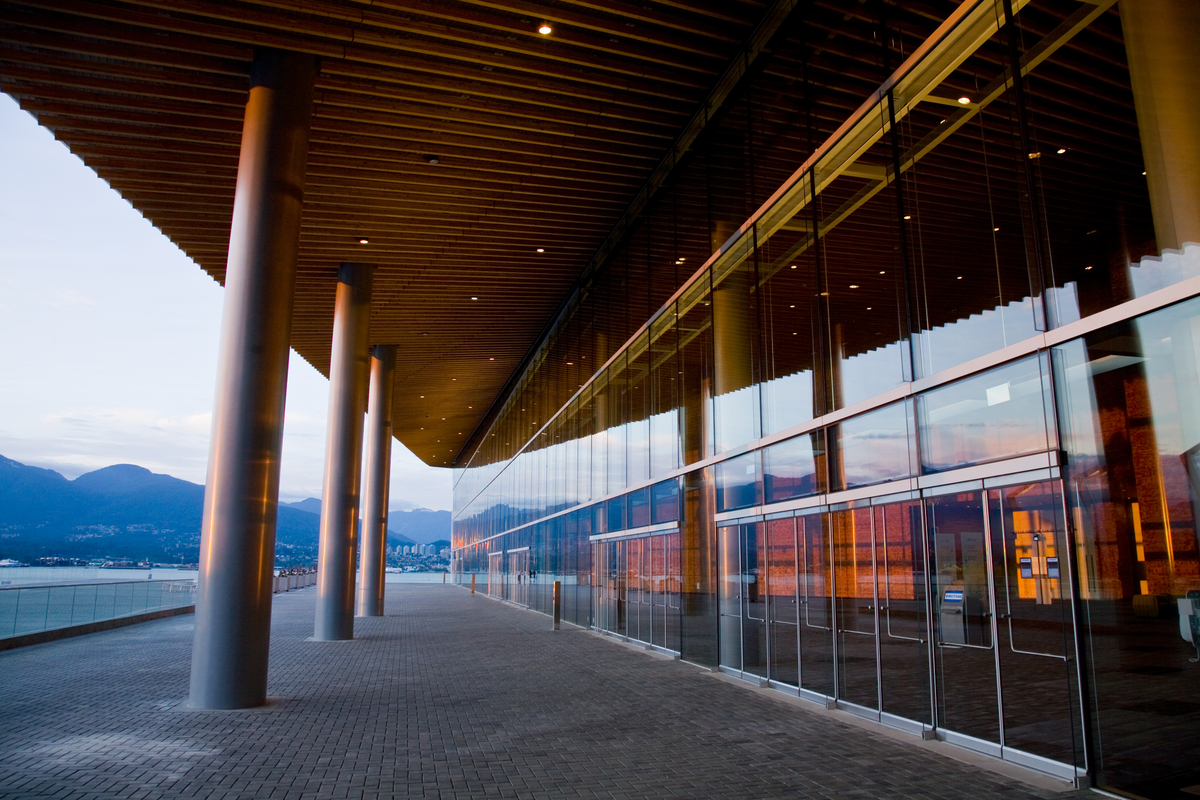 在温哥华会议中心西大楼的玻璃外墙附近，展示了边缘尺寸木材的外部天花板软垫和人行道覆盖物