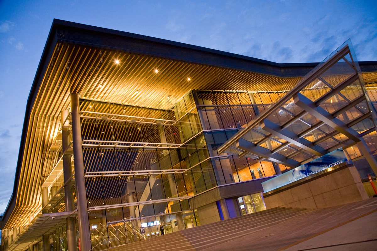 温哥华会议中心西大楼多层低层的外部夜景，展示了大量使用的木材，内部和外部镶板，装饰和外部玻璃