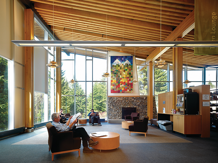被占用的惠斯勒公共图书馆室内阳光明媚的白天景观，展示回收的道格拉斯冷杉木制品，以木材柱子和梁为特色，被动房屋/高效率，和木制预制建筑技术