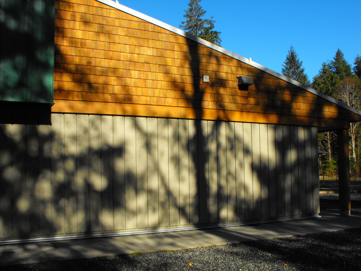 泽巴洛斯小学/中学白天的外部图像，显示木墙板和木墙板